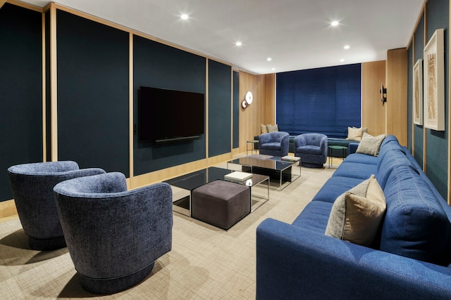 cinema room featuring light colored carpet and wooden walls