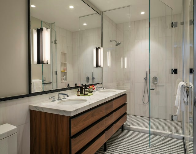 bathroom with vanity, toilet, an enclosed shower, and tile walls