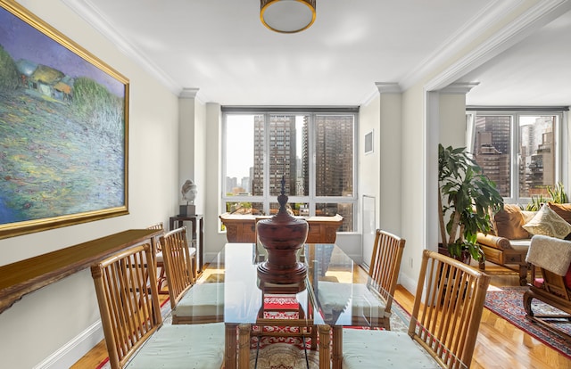 dining area with light wood-type flooring and crown molding