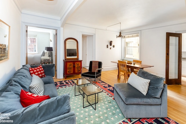 living room with french doors, wood-type flooring, and ornamental molding