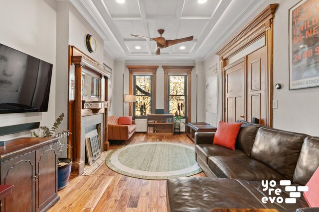 interior space with coffered ceiling, light hardwood / wood-style flooring, ceiling fan, ornamental molding, and beam ceiling