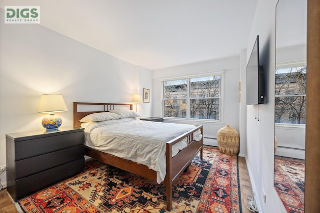 bedroom featuring multiple windows and a baseboard radiator