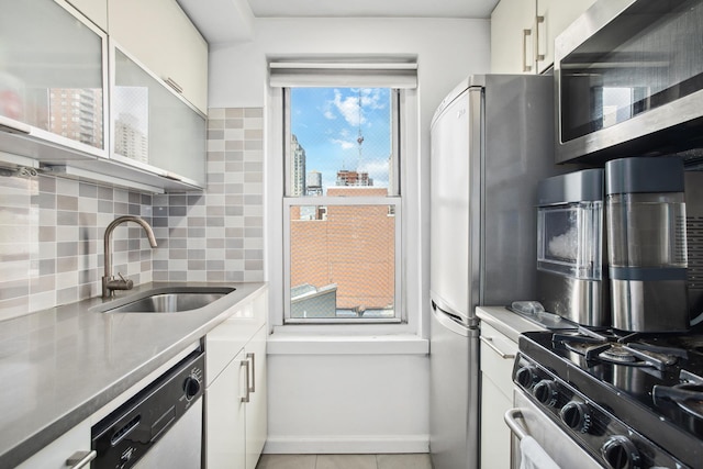 kitchen featuring white cabinets, sink, appliances with stainless steel finishes, and tasteful backsplash