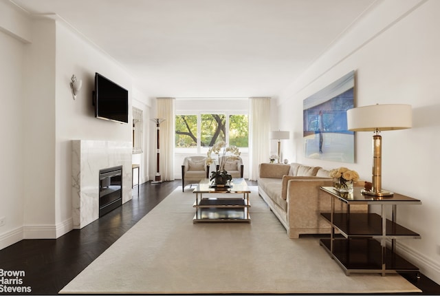 living room with a high end fireplace and hardwood / wood-style floors