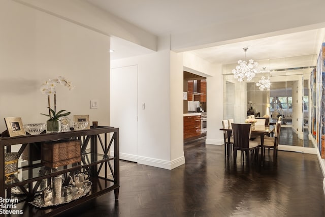 dining room with dark parquet floors and a notable chandelier