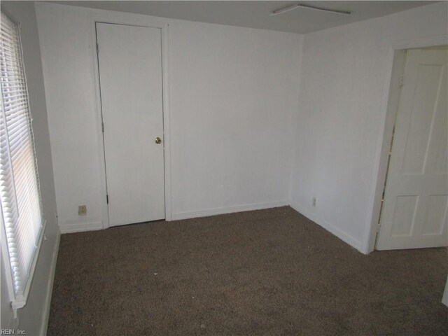 403 S Church St, Smithfield, VA 23430 - unfurnished bedroom with dark colored carpet and multiple windows