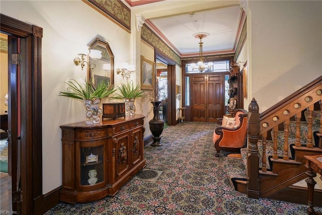 entryway with an inviting chandelier and ornamental molding