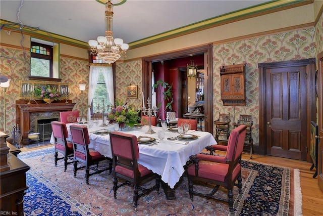 dining area with an inviting chandelier, ornamental molding, and light hardwood / wood-style floors