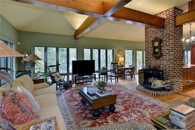 living room featuring a chandelier, beamed ceiling, brick wall, light wood-type flooring, and a fireplace