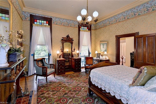 bedroom with ornamental molding, dark hardwood / wood-style floors, and an inviting chandelier