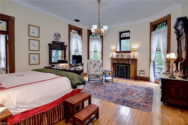 bedroom featuring an inviting chandelier, light hardwood / wood-style floors, and ornamental molding