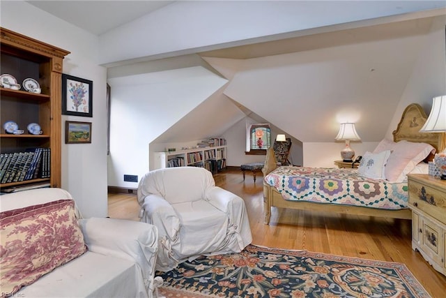 bedroom with light hardwood / wood-style flooring and lofted ceiling