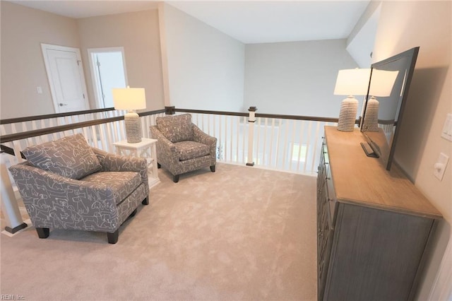 sitting room with lofted ceiling and light colored carpet