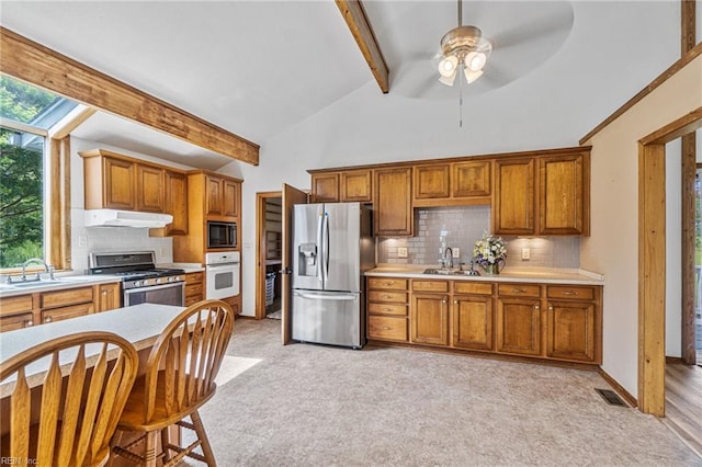 kitchen with tasteful backsplash, ceiling fan, stainless steel appliances, sink, and light hardwood / wood-style flooring