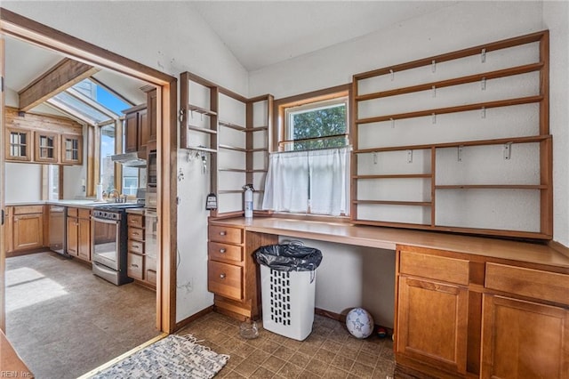 interior space featuring lofted ceiling with skylight and dark tile floors