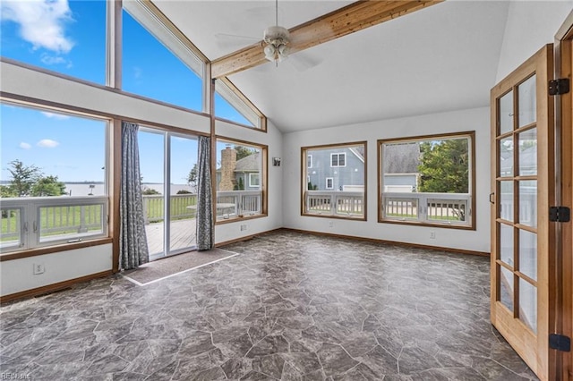 unfurnished sunroom featuring ceiling fan, vaulted ceiling with beams, and a wealth of natural light