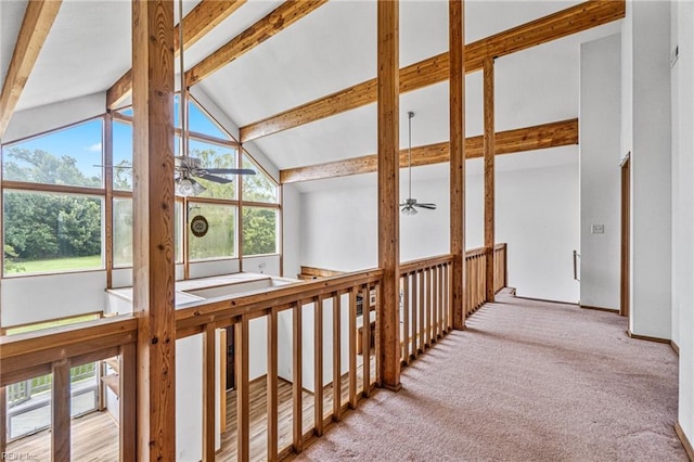 corridor with lofted ceiling with beams, light carpet, and a healthy amount of sunlight