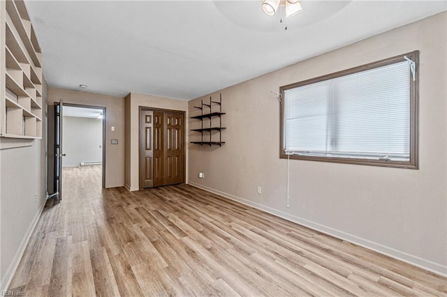 empty room with ceiling fan and light wood-type flooring