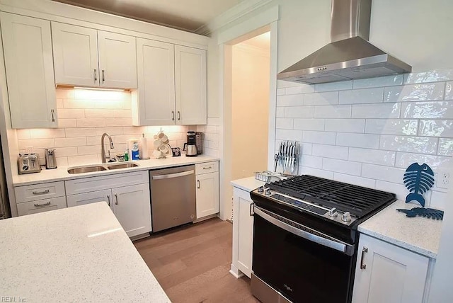 kitchen featuring decorative backsplash, wall chimney exhaust hood, stainless steel appliances, sink, and white cabinetry