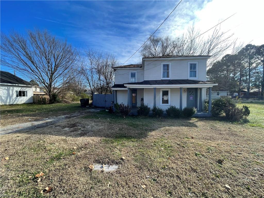 view of front facade featuring dirt driveway, a porch, and a front yard