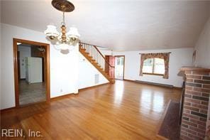 364 Millers Ln, Susan, VA 23163 - unfurnished living room with stairs, a fireplace, and wood finished floors