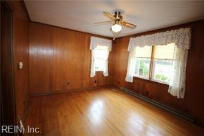 364 Millers Ln, Susan, VA 23163 - spare room with ceiling fan, a baseboard heating unit, wood walls, and wood finished floors