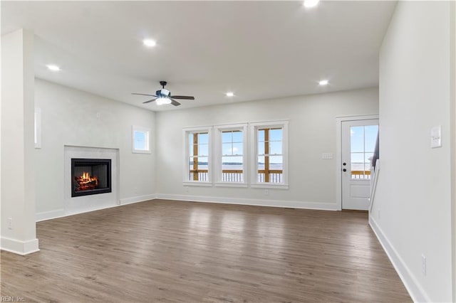 unfurnished living room with ceiling fan and dark hardwood / wood-style flooring