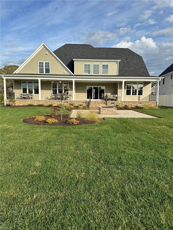 rear view of house with a patio and a lawn