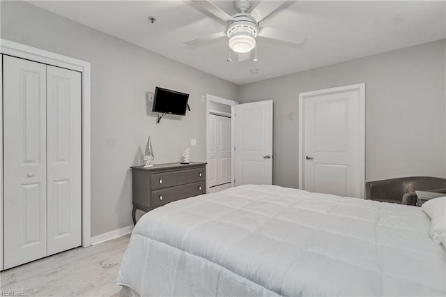 bedroom featuring light hardwood / wood-style flooring, multiple closets, and ceiling fan