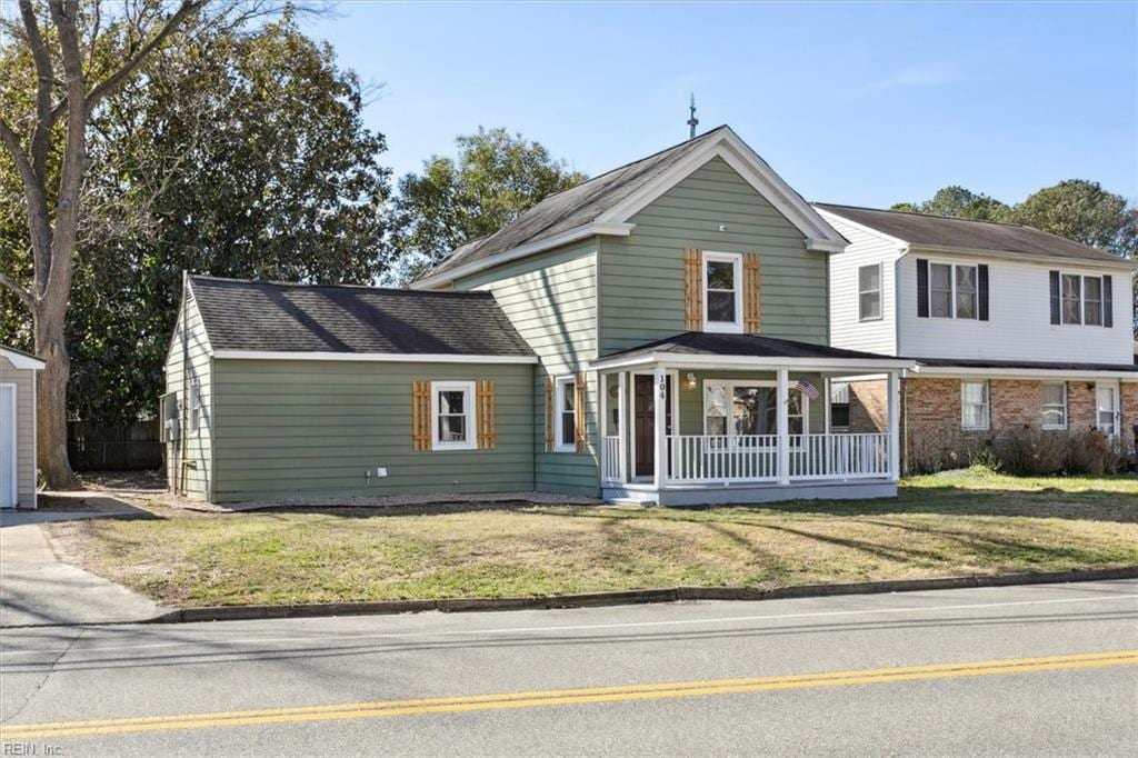 view of front of home with covered porch and a front lawn