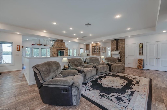 living room with light hardwood / wood-style floors and a wood stove