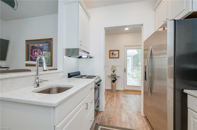 kitchen featuring light hardwood / wood-style flooring, stainless steel appliances, wall chimney range hood, and white cabinetry