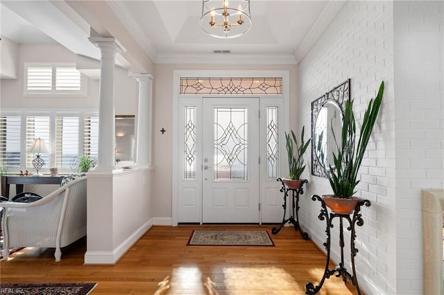 entryway with light hardwood / wood-style floors, a wealth of natural light, a chandelier, and ornate columns