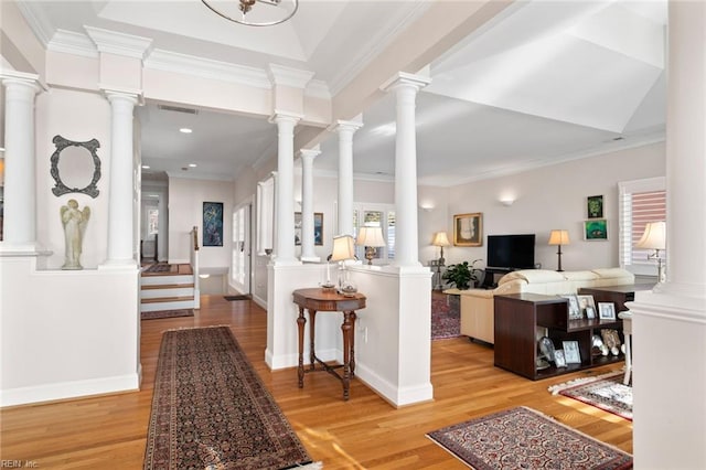 interior space featuring ornamental molding, ornate columns, and light wood-type flooring