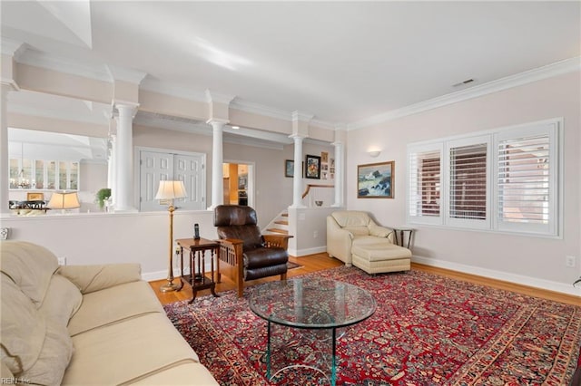 living room featuring light wood-type flooring, ornamental molding, and ornate columns