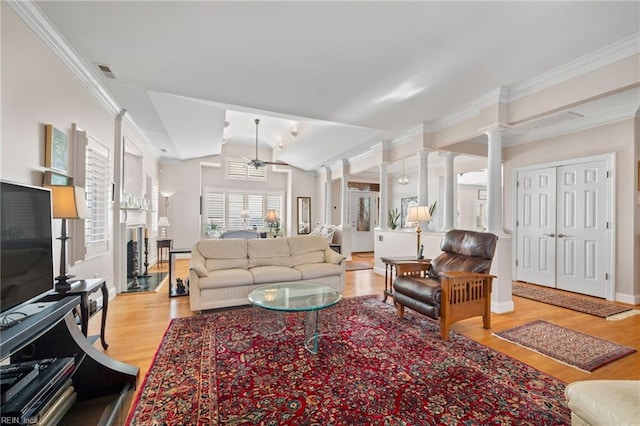 living room with ceiling fan, light wood-type flooring, vaulted ceiling, ornate columns, and ornamental molding