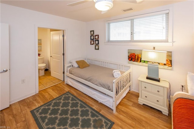 tiled bedroom with connected bathroom and ceiling fan