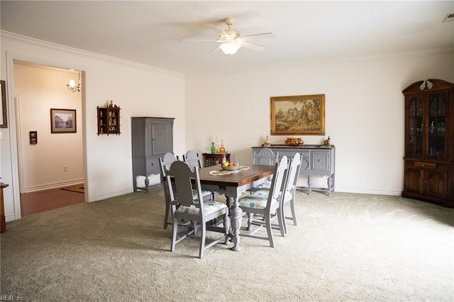 carpeted dining room with ceiling fan and ornamental molding