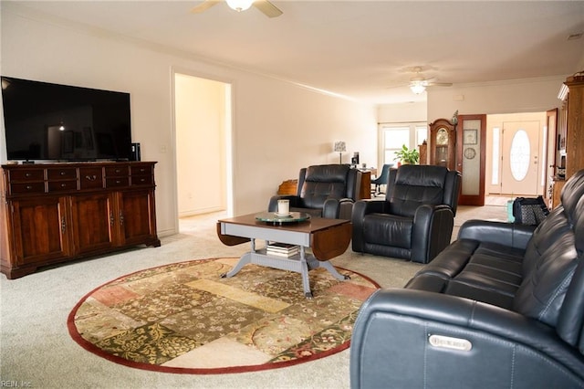 carpeted living room with ceiling fan and ornamental molding