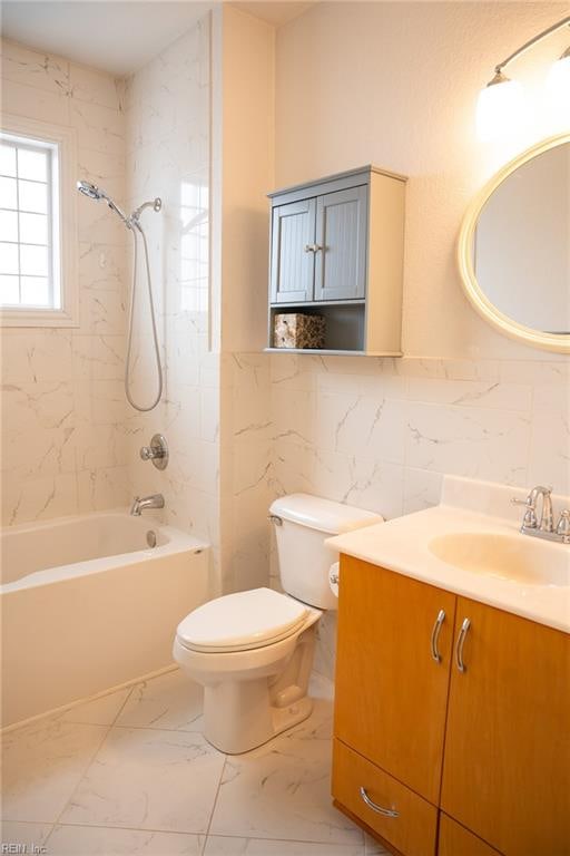 full bathroom with tiled shower / bath combo, vanity, tile walls, tile flooring, and toilet