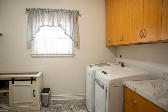 washroom with cabinets, washer and dryer, and light tile floors