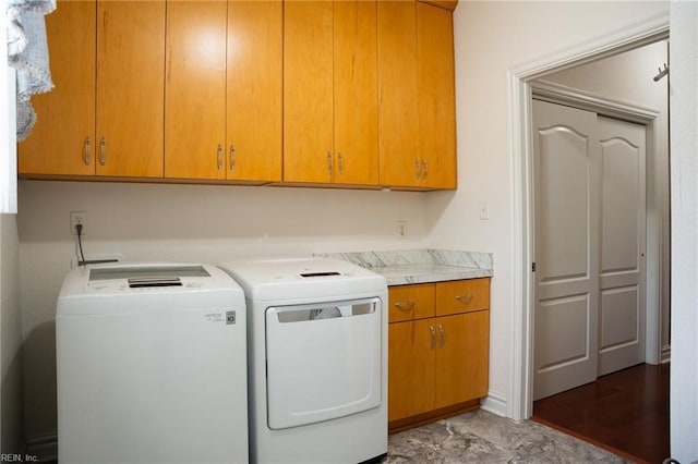 laundry area with cabinets, tile floors, and separate washer and dryer