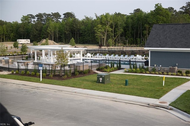 exterior space featuring a front yard, a community pool, a water view, and central AC