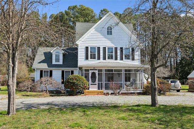 view of front of house with a front yard and a sunroom