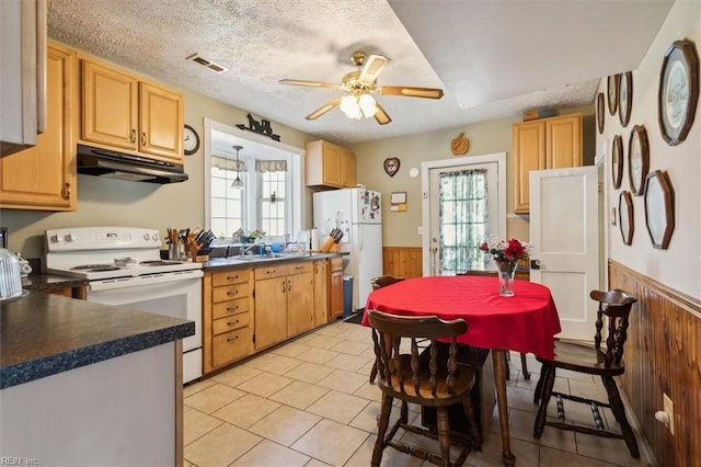 kitchen with ceiling fan, white appliances, a wealth of natural light, and light tile flooring