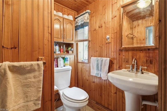 bathroom with wood walls and toilet