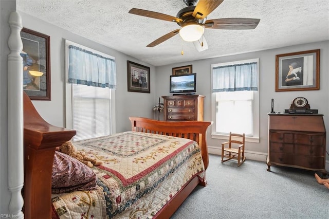 bedroom featuring ceiling fan, light colored carpet, and a textured ceiling