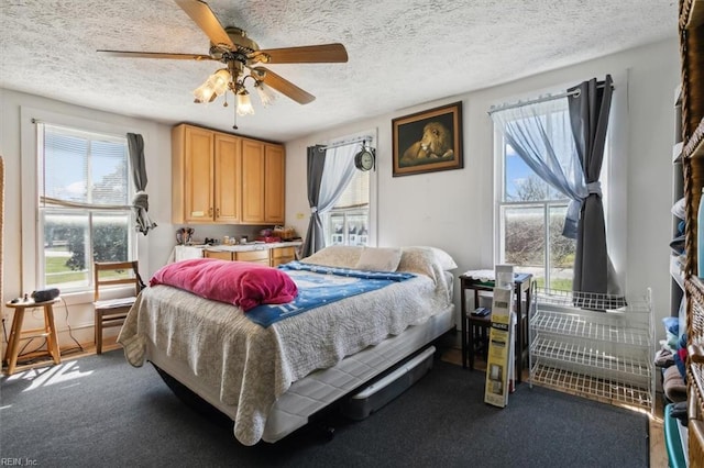 bedroom featuring ceiling fan, a textured ceiling, and carpet floors