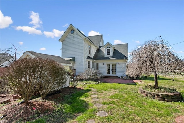 back of property with a yard and french doors