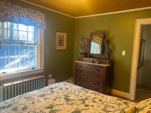 bedroom with radiator heating unit, crown molding, and multiple windows